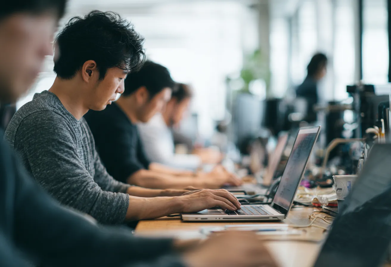 a_group_of_men_are_working_on_laptops