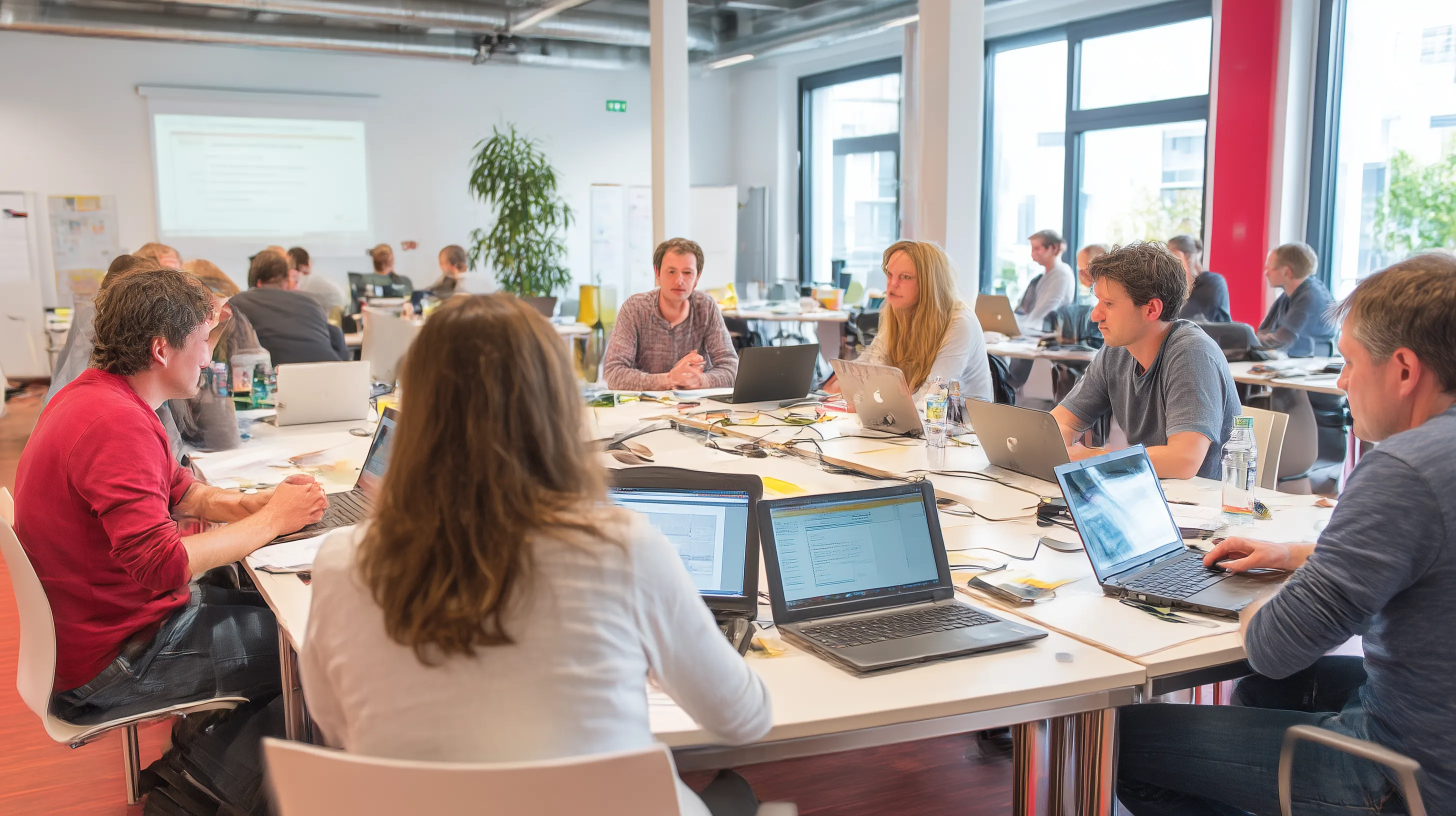 karlwe_acht_personen_in_einem_lebendigen_workshopraum_mit_laptop
