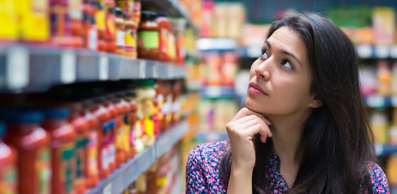 _a_hispanic_woman_in_her_mid-20s_is_looking_at_the_shelf