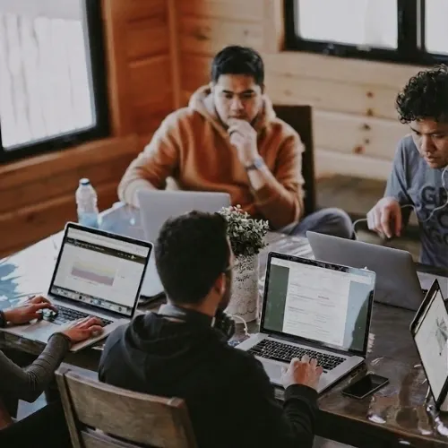 A small team working together on laptops around a table